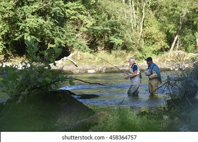 Flyfisherman With Fishing Guide In River