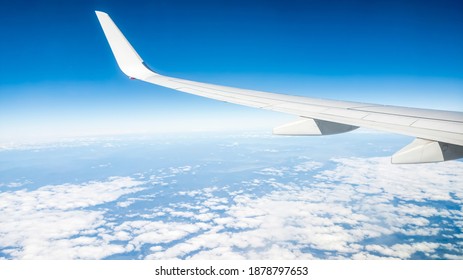 Flying Above The Sea Of Clouds. Features Bright Blue Sky And White Clouds. Slight Curvature Of The Earth At The Horizon.