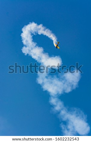 Similar – Red plane with propeller flying upward with white smoke