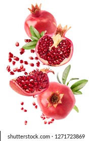 Flying in air fresh ripe whole and cut pomegranate with seeds and leaves isolated on white background. High resolution image
