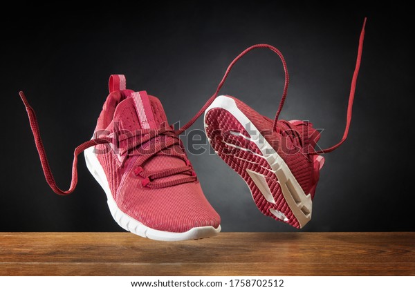 Flying in the\
air pink running sports shoes. Abstract shopping concept.\
Levitation sports shoes with flying\
laces