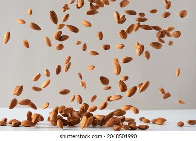 Flying Almond Nuts. Fresh Raw Almonds Fall On A White Background.Flying Almond Nuts. Fresh Raw Almonds Fall On A White Background.