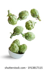 Flying artichokes in a bowl isolated from the white background