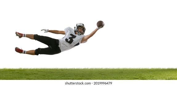 Flying, Catching Ball. Portrait Of American Football Player Training Isolated On White Studio Background With Green Grass. Concept Of Sport, Movement, Achievements. Copy Space For Ad