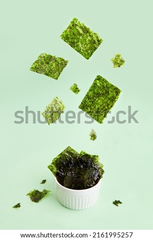 Flying crispy nori seaweed. Healthy snack. Traditional Japanese dry seaweed sheets. Creative concept, levitation.