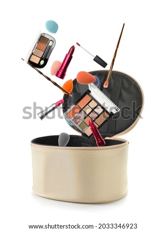 Flying decorative cosmetics with bag on white background