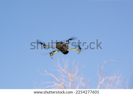 Flying drone with blue sky and clouds. copy space. A modern quadcopter with a high resolution camera soars in the air.
