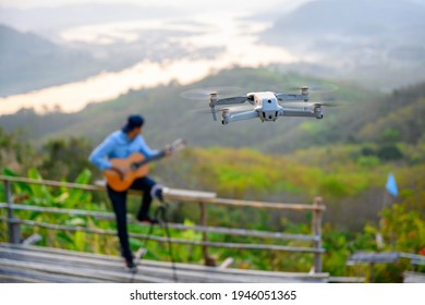 Flying Drone Close Up Taking High Angle Photos And Videos People Play Guitar And Sing In The Beautiful Nature Of Thailand. Use The Drone To Take High-angle Shots.