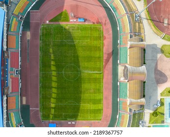 Flying A Drone Over A Modern Football Field. View Of The Manicured Lawn Of The Stadium And The Treadmill From Above. Irrigation And Lawn Care Systems Of The Sports Complex.