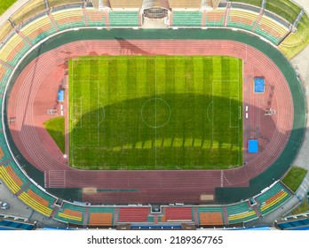 Flying A Drone Over A Modern Football Field. View Of The Manicured Lawn Of The Stadium And The Treadmill From Above. Irrigation And Lawn Care Systems Of The Sports Complex.