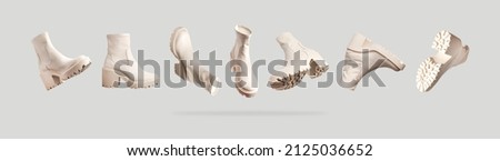 Flying fashionable beige leather women's boots with rough sole isolated on gray background. Trendy spring autumn shoes. Creative minimalistic shoes background. Layout with footwear Mock up