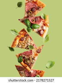 Flying Food. Pizza Slices With Cheese, Sausages, Salami, Olives And Basil In Levitation On Olive Background. Vertical Orientation