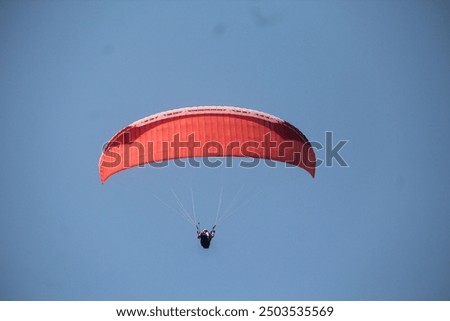Flying fox rides that go around the top of Melasti Beach in Bali with red parachutes
