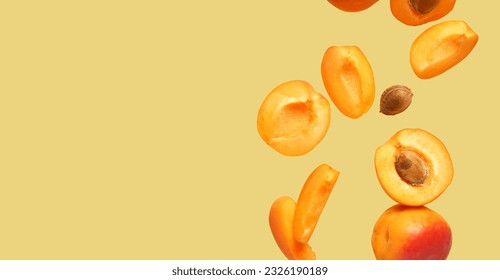 Flying fresh apricots on color background with space for text