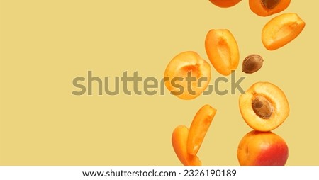Flying fresh apricots on color background with space for text