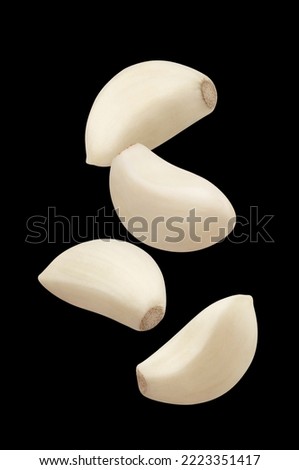 Flying garlic cloves, isolated on black background