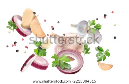 Flying garlic, onion, parsley and peppercorn isolated on white
