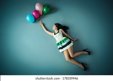 Flying Girl With Balloons In Studio