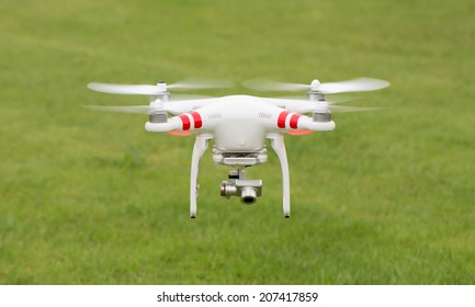Flying helicopter with camera over grass