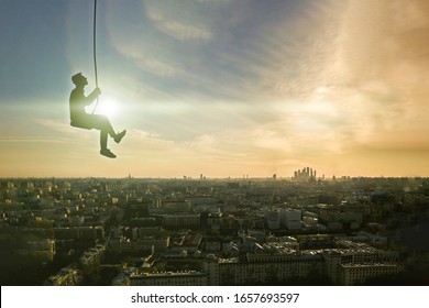 flying high in the sky with clouds, man on a swing, relax and dream in mind concept