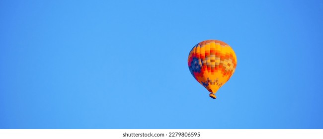 Flying hot air balloon against bright blue sky - Shutterstock ID 2279806595