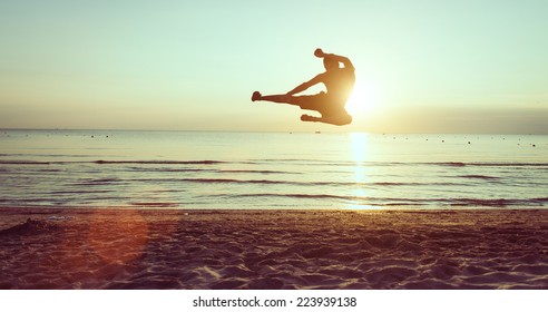 Flying Kick On The Beach At Dawn. Martial Arts And Fitness