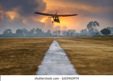 Flying microlight aircrafts flying pilot landing on runway in rural country, The motorized landing.