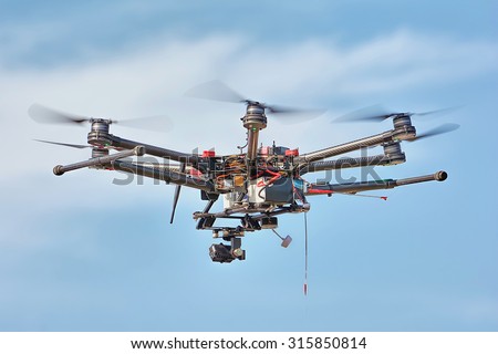 A flying multicopter with camera in beautiful sky