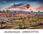 Flying on balloons early morning in Cappadocia. Amazing summer scene of Red Rose valley, Goreme village location, Turkey, Asia. Traveling concept background.
