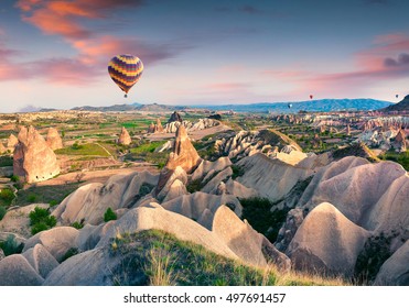 Flying On The Balloons Early Morning In Cappadocia. Colorful Sunrise In Red Rose Valley, Goreme Village Location, Turkey, Asia. Artistic Style Post Processed Photo.