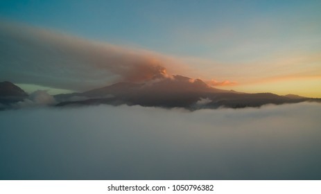 flying over the clouds, Calbuco volcano with volcanic activity and an ash plume, at sunset - Powered by Shutterstock