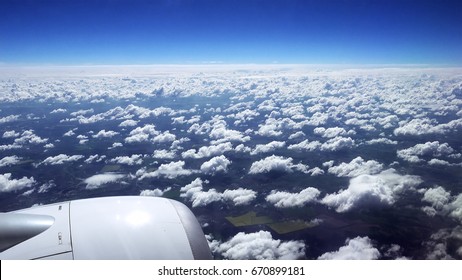 Flying over the clouds. View from plane aircraft passenger window. Clouds and skyline horizon panoramic view.