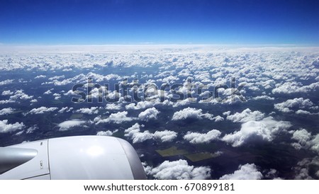 Flying over the clouds. View from plane aircraft passenger window. Clouds and skyline horizon panoramic view.