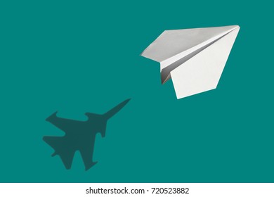 Flying a paper airplane with aggressive shadow combat aircraft-fighter on a Marrs Green background - Shutterstock ID 720523882