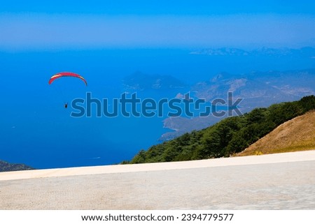 Flying paraglider at the top of Babadag mountain in Turkey. Oludeniz or Blue Lagoon is a beach resort in the Fethiye district of Mugla Province, Turkey.