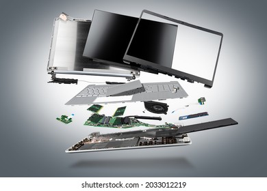 flying parts of a notebook computer. hardware components mainboard cpu processor display RAM cables and cooling fan flying out of silver laptop PC case on dark gray exploded view background