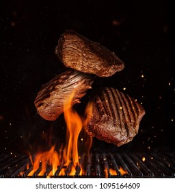 Flying pieces of beef rump steaks above grill flames, isolated on black background. Concept of flying food, very high resolution image - Shutterstock ID 1095164609
