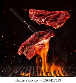 Flying pieces of beef steaks above grill grid, isolated on black background. Concept of flying food, very high resolution image - Shutterstock ID 1098417353