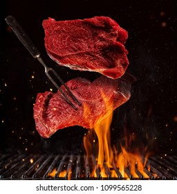 Flying pieces of beef steaks above grill grid, isolated on black background. Concept of flying food, very high resolution image - Shutterstock ID 1099565228
