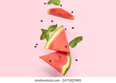 Flying pieces of fresh watermelon with mint and seeds on pink background - Powered by Shutterstock