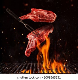 Flying pieces of pork chops steaks above grill grid, isolated on black background. Concept of flying food, very high resolution image - Shutterstock ID 1099565231