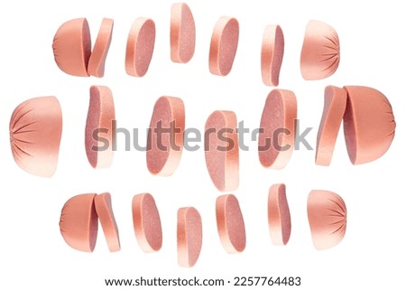 Flying pieces of sausage isolated on blue background.Delicious meat product.Sliced ​​sausage drops on a blue background. Sliced ​​milk sausage isolated.Milk sausages.Sausages.Lots of flying sausages