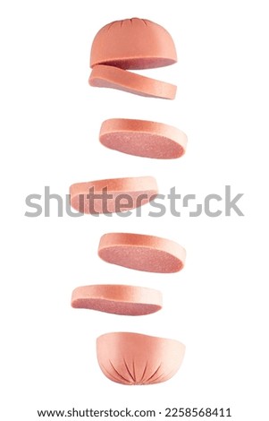 Flying pieces of sausage isolated on blue background. Delicious meat product. Sliced ​​sausage drops on a blue background. Sliced ​​milk sausage isolated. Milk sausages. Sausages.