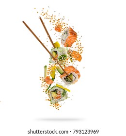Flying pieces of sushi with wooden chopsticks, separated on white background. Flying food and motion concept. Very high resolution image