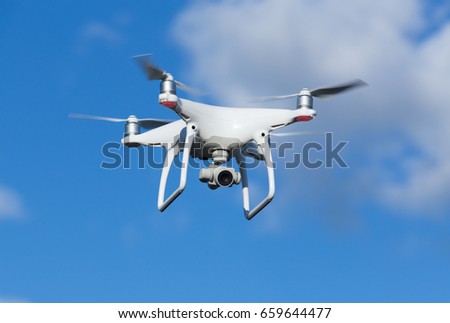 flying quadcopter with camera in blue sky