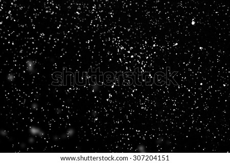 Flying rain or snow on black background