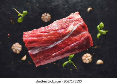 Flying Raw Beef Brisket On Dark Background