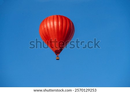 Flying red hot air balloon in the blue sky