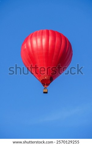 Flying red hot air balloon in the blue sky