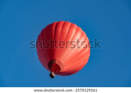 Flying red hot air balloon in the blue sky